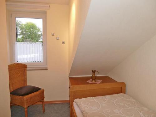 - une chambre avec un lit, une chaise et une fenêtre dans l'établissement Ferienwohnung Hacke, à Schmallenberg