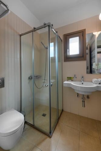 a bathroom with a shower and a toilet and a sink at Lithos by Spyros & Flora in Agios Ioannis Mykonos