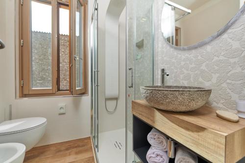 La salle de bains est pourvue d'un lavabo et d'une douche en verre. dans l'établissement Hotel Al Rio Se, à Limone sul Garda