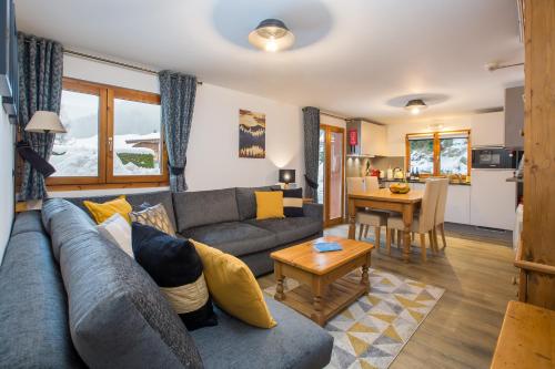 een woonkamer met een bank en een tafel bij Simply Morzine - Apartment des Montagnes in Morzine