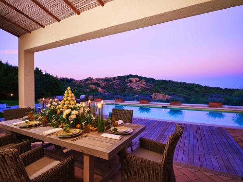 a table with flowers on top of a patio at Borgo Smeraldo Villas in Arzachena