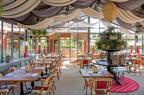 カパルビオにあるLocanda Rossaの木製のテーブルと椅子、窓のあるレストラン
