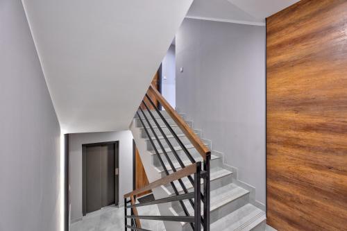 a staircase in a house with white walls and wood at Promenada Apartmani Zlatibor in Zlatibor