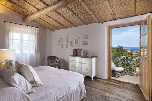 a bedroom with a bed and a view of the ocean at Borgo Smeraldo Villas in Arzachena