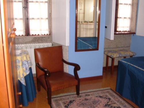 a chair in a room with a table and a mirror at Casa Xan da Pena in Villarmayor
