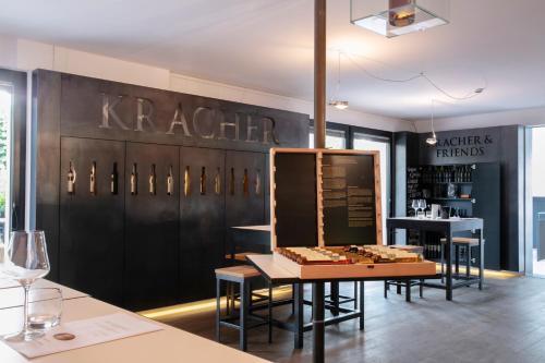 ein Restaurant mit einer schwarzen Wand mit einem Tisch und Stühlen in der Unterkunft KRACHER Guesthouse No 5 in Illmitz