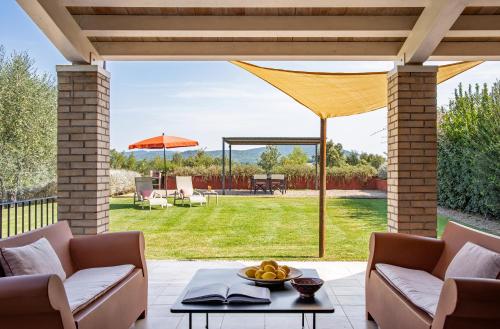 a patio with a table and chairs and an umbrella at Locanda Rossa in Capalbio
