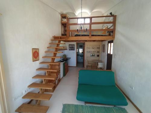 - un escalier en colimaçon dans une petite chambre avec un canapé vert dans l'établissement Casa Norte, à Baia das Gatas