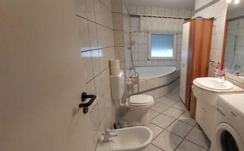 La salle de bains est pourvue de toilettes, d'un lavabo et d'une baignoire. dans l'établissement Monteur-, Ferienwohnung mit Balkon in Hanau bei Frankfurt und Aschaffenburg, à Hanau