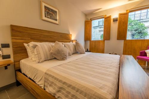 a bedroom with a large bed with a wooden headboard at Casa Olié in Oaxaca City