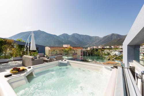a hot tub on the roof of a building with mountains at Akrogiali Apartments "by Checkin" in Balíon