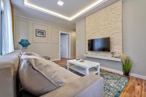 a living room with a couch and a tv at Onix Residence in Zlatibor