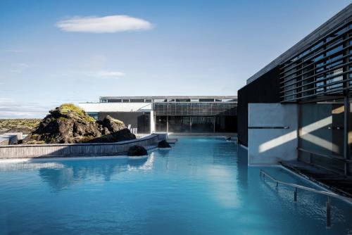 a pool of blue water in front of a building at Silica Hotel at Blue Lagoon Iceland in Grindavík