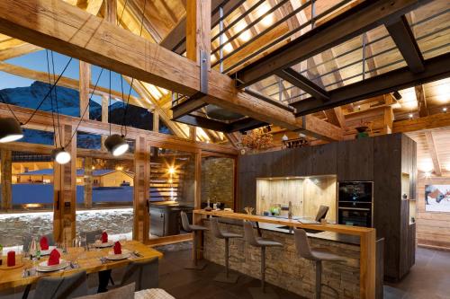 une salle à manger avec des plafonds en bois et des tables en bois dans l'établissement Chalet Prestige l'Atelier Lodge, à Les Deux Alpes