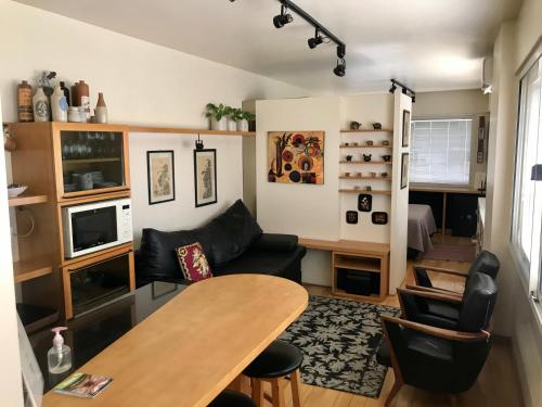 a living room with a table and a couch at Departamento en Av Corrientes con estacionamiento para autos menores a 2000 kilos in Buenos Aires