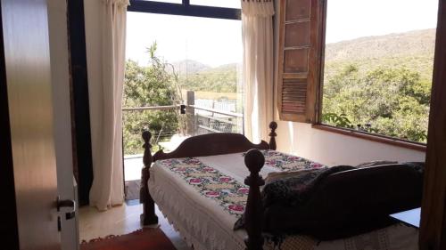um quarto com uma cama e uma grande janela em Casas da Paty em Santana do Riacho