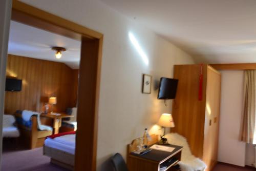 ein Hotelzimmer mit einem Schlafzimmer mit einem Bett und einem Tisch in der Unterkunft Hotel Jägerhof garni in Bernau am Chiemsee