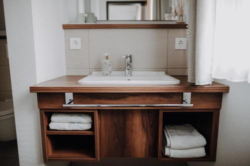 a bathroom vanity with a sink and towels at Okelmann's - Entspannte Achtsamkeit - Bewusster Lifestyle in Warpe