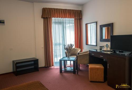 a hotel room with a couch and a television and a table at Pension Pantheon in Poiana Brasov