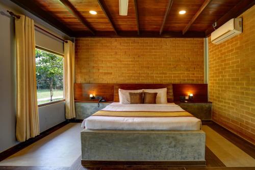 una camera con un grande letto in un muro di mattoni di Kaveri Resort Sigiriya a Sigiriya