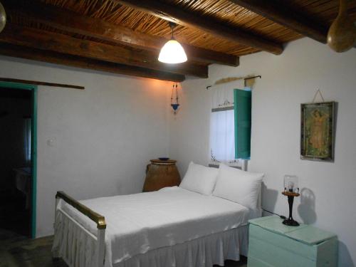 um quarto com uma cama branca num quarto em Το σπίτι του Παππού. em Patmos