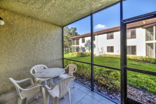 a patio with a table and chairs and a view of a building at 4411 Shorewalk 15 min to Beach and 5 mins to IMG in Bradenton