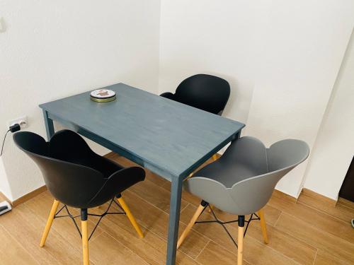 a blue table with four chairs in a room at Apartman Maris in Šišava