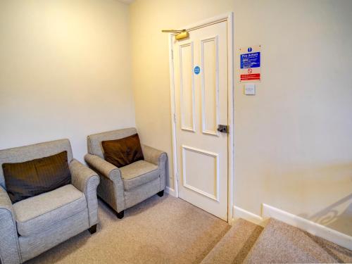 two chairs and a door in a room at George & Dragon Inn in Chichester