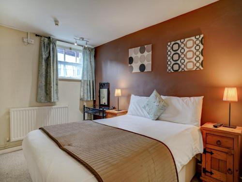 een slaapkamer met een groot bed en een raam bij George & Dragon Inn in Chichester