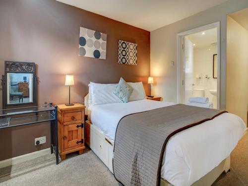 a bedroom with a large bed and a mirror at George & Dragon Inn in Chichester