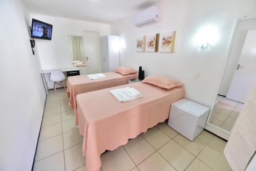 a room with two beds and a mirror at LIVE IN FORTALEZA HOTEL in Fortaleza