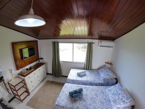 a bedroom with two beds and a wooden ceiling at Casa dos Tubarões in Fernando de Noronha