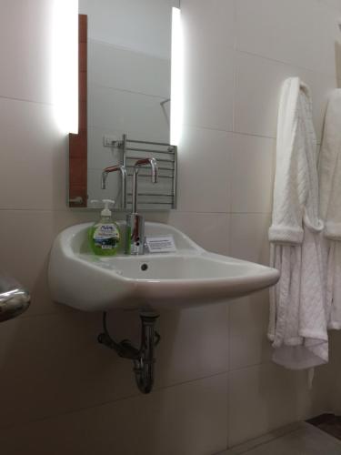 a white sink in a bathroom with towels at Zen Home & Garden House in Cieneguilla