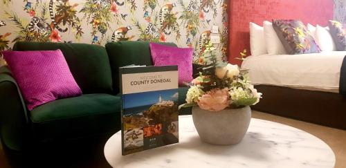 a room with a couch and a table with a vase at Nesbitt Arms Boutique Hotel in Ardara