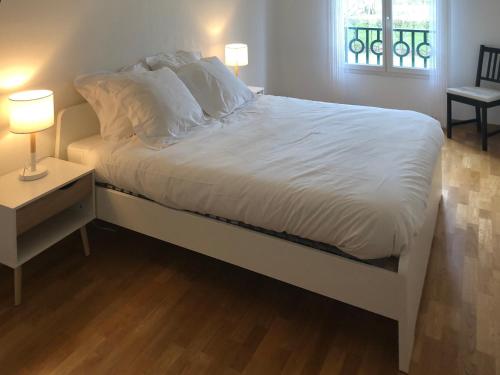 - une chambre avec un lit doté de draps blancs et une fenêtre dans l'établissement La Pommeray Geneva, à Veigy-Foncenex