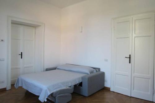 Cama pequeña en habitación con 2 puertas blancas en Villa Peachey, Intero piano con giardino en Stresa