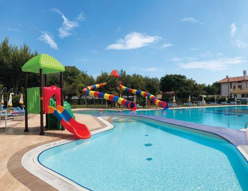 a swimming pool with a water slide in a resort at Camping Parco Capraro in Lido di Jesolo