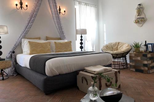 een slaapkamer met een groot bed en een stoel bij Chic Suite Sequa in Taviras Historical Centre in Tavira