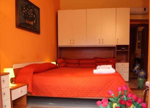 a bedroom with a red bed with white cabinets at B&B Villa Casablanca in Enna