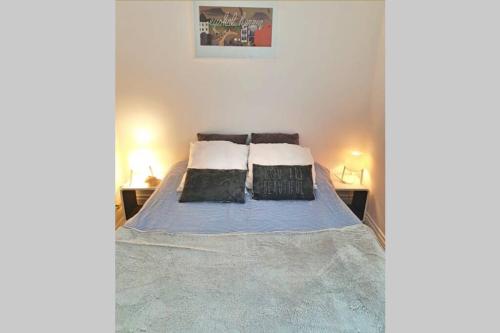 une chambre avec un lit avec deux oreillers dessus dans l'établissement Itsas Aldea T2 à 3 min à pieds de la baie de St Jean de Luz, à Saint-Jean-de-Luz