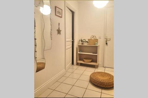 - une salle de bains avec un panier sur un sol carrelé dans l'établissement Itsas Aldea T2 à 3 min à pieds de la baie de St Jean de Luz, à Saint-Jean-de-Luz