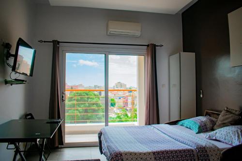 1 dormitorio con 1 cama y puerta corredera de cristal en Le First Concept, en Dakar
