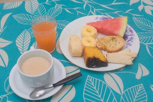 - une table avec deux assiettes de nourriture et une tasse de café dans l'établissement Hotel Novo Lar, à Cuiabá