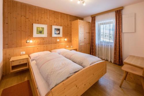 a bed in a room with a wooden wall at Apartment Pustertal in Mühlbach