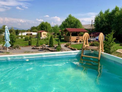 una piscina con 2 sillas en un patio en Picnic Park, en Rakoshyno