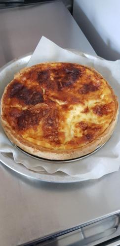 eine Käsepizza auf einem Teller auf einem Tisch in der Unterkunft La Ceriseraie in La Gorgue