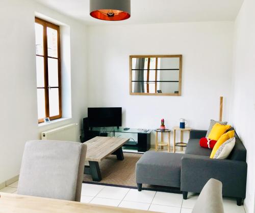a living room with a couch and a table at Le 61 bis in Saint-Valery-sur-Somme