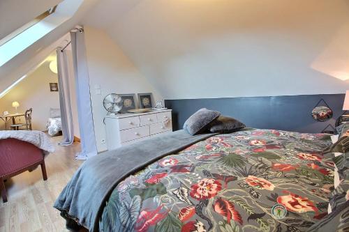 a bedroom with a bed with a colorful blanket at Gîte Losten Ar Goguès in Trédarzec