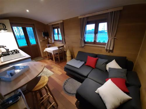 a living room with a couch and a table at Roulotte les Mésanges in Rebecq-Rognon