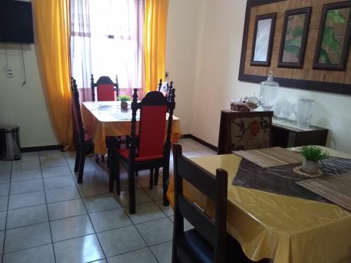 a dining room with a table and a table and chairs at Pousada Emilly in Joinville